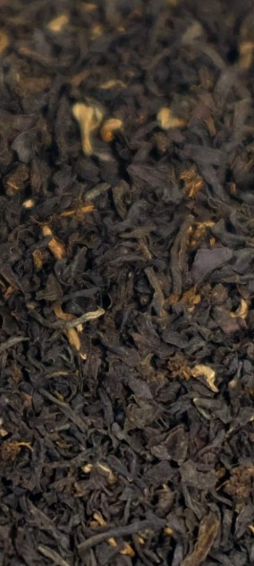 Een dampende kop English Breakfast thee naast een klassiek Engels ontbijt